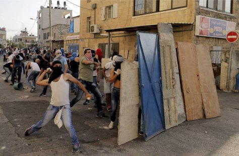 Palestinesi lanciano pietre contro la polizia israeliana durante gli scontri a Shuafat, un quartiere arabo di Gerusalemme, il 5 ottobre 2015. (Ammar Awad, Reuters/Contrasto)