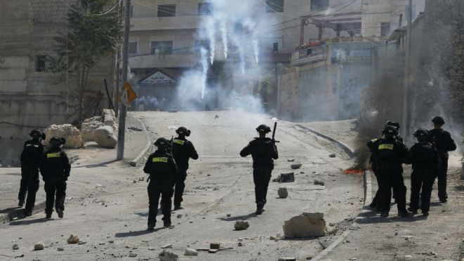 An Israeli police officer fires tear gas during clashes with Palestinian stone-throwers in the East Jerusalem neighbourhood of Isawiyah, October 4, 2015. Reuters 